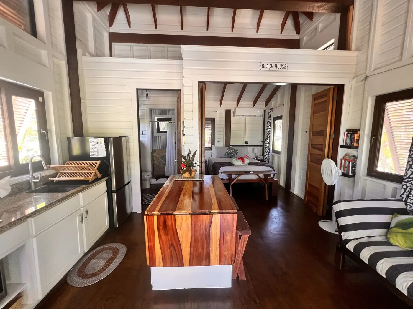 Casita interior with a hardwood table, kitchenette, and striped sofa