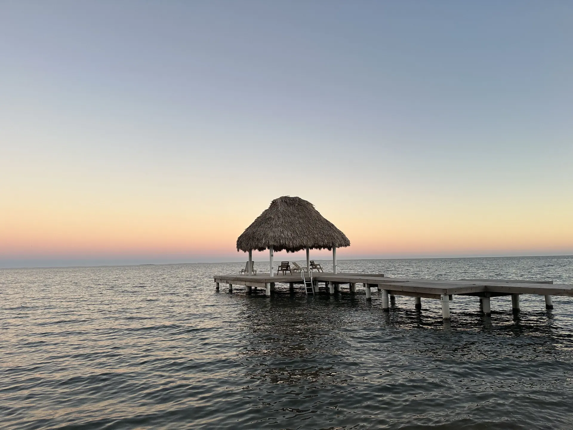 Sunrise over La Vida Belize’s private pier and palapa, just north of Placencia