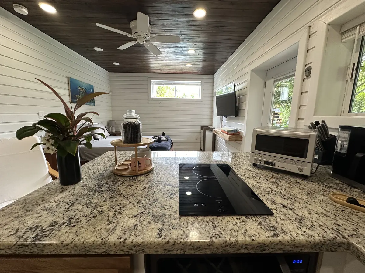 Studio kitchen counter with a granite top and cooktop